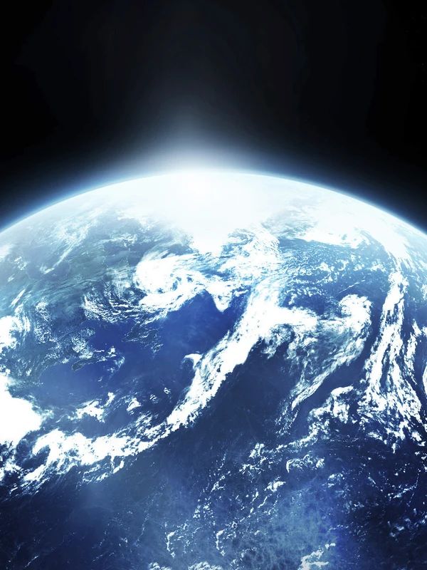 Planet Earth seen from space, with sunlight breaking over the horizon